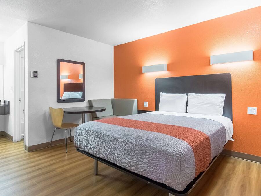Ein Hotelzimmer mit Bett, Schreibtisch und Stuhl.