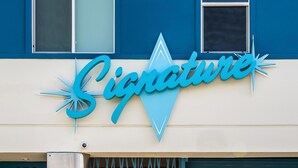 A building with a sign that reads 'Signature' in a stylized font. - Signature Inn Merced Yosemite Parkway (Merced)