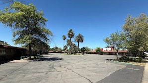 A parking lot with trees and buildings in the background. - Oroville Value Suites (Oroville)