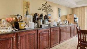 Una cocina de hotel con un sistema de bufé, que incluye diversos electrodomésticos y alimentos.