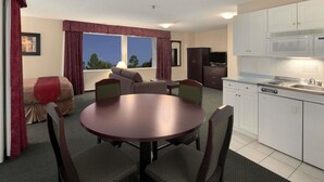 Un espacio habitable compacto con una mesa de comedor, sillas, un sofá y una kitchenette.