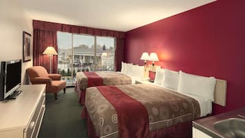 Een hotelkamer met twee bedden, een bureau, een stoel en een televisie.