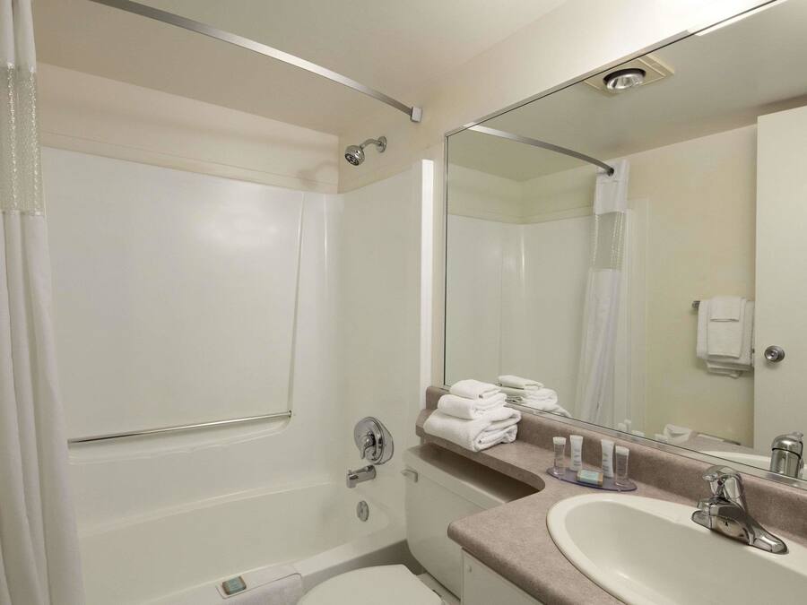 A modern bathroom with a bathtub, a sink, and a large mirror.