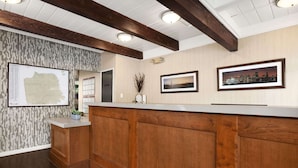 A reception area with a wooden reception desk, a map on the wall, and framed pictures.