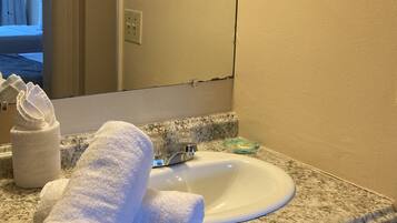 A bathroom with a granite countertop, a white sink, and a towel rack.