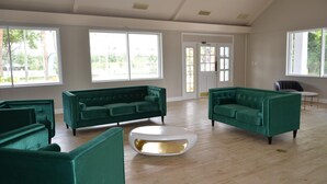 Una habitació àmplia amb dos sofàs verds i una taula de cafè blanca.