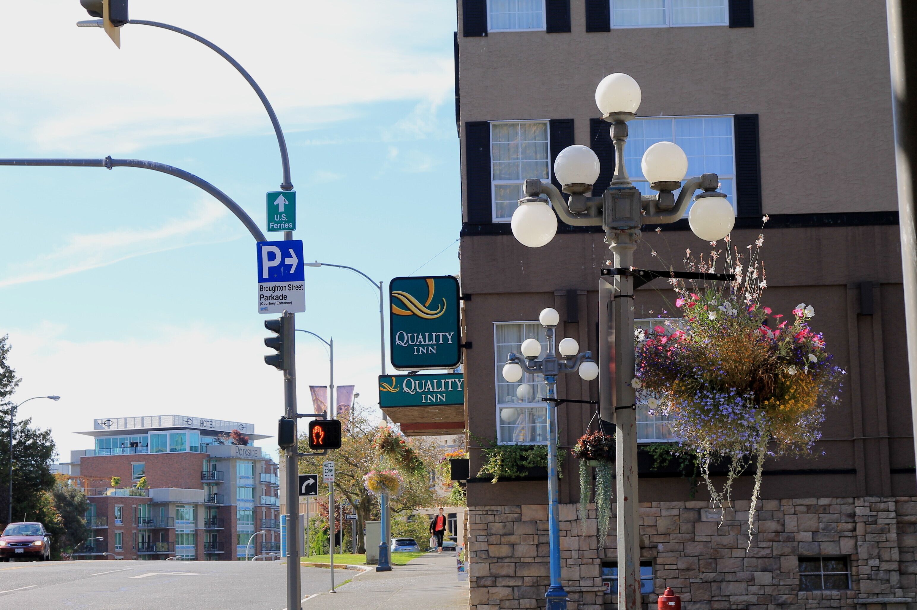 A hotel with a sign indicating a parking area and a Quality Inn sign.