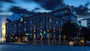 A hotel with a modern design, featuring a prominent entrance, multiple windows, and a well-lit facade.
