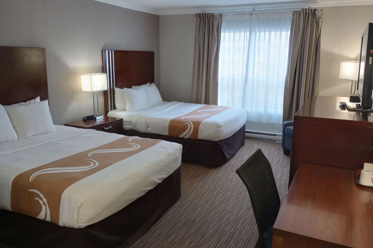 Camas con pillow-top, escritorio y cortinas blackout