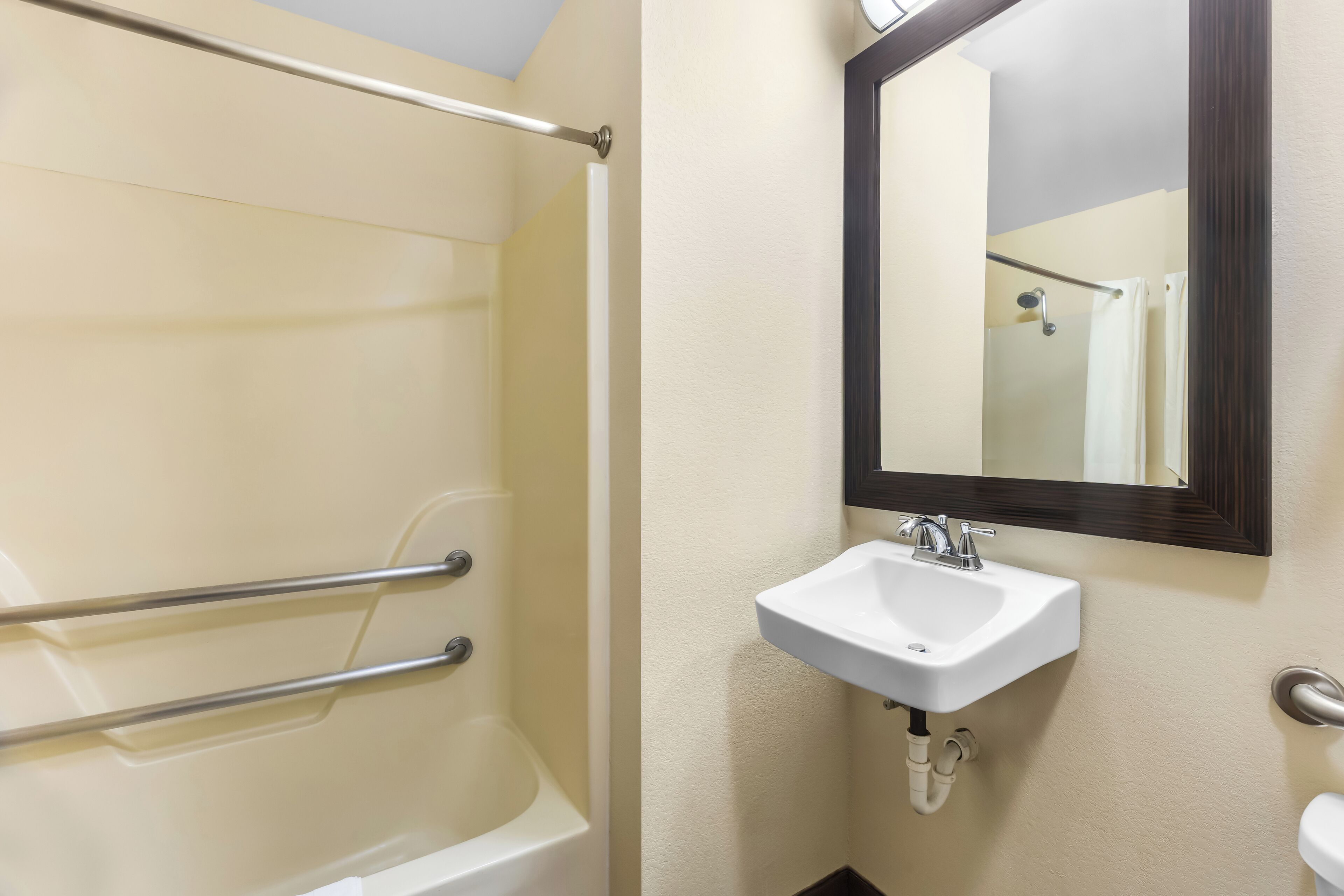 Un baño con bañera, lavamanos y espejo.
