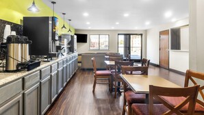 Una cocina moderna con electrodomésticos de acero inoxidable, armarios de madera y una pared de acento de color amarillo brillante.