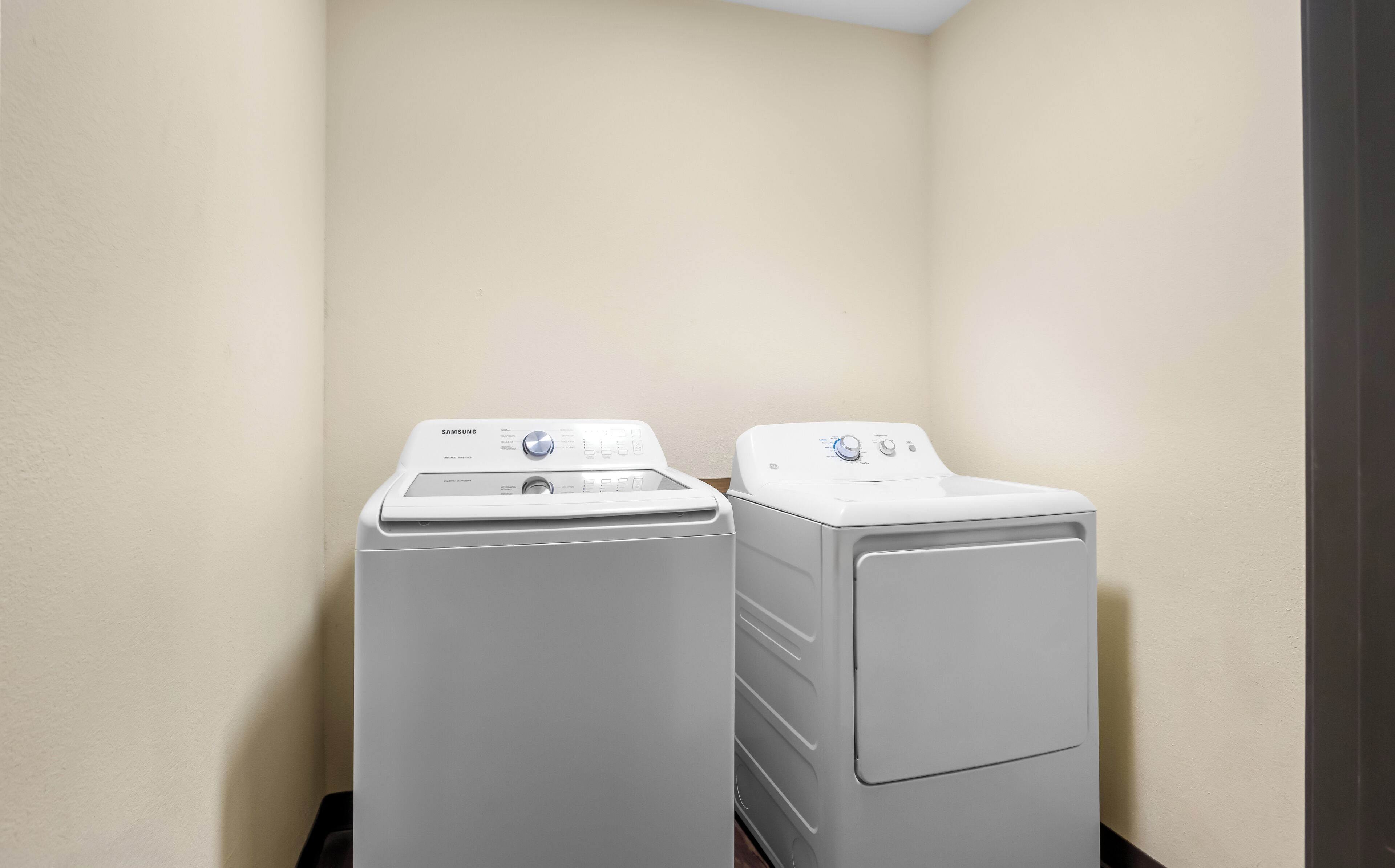 A laundry room with two white front-loading washing machines.