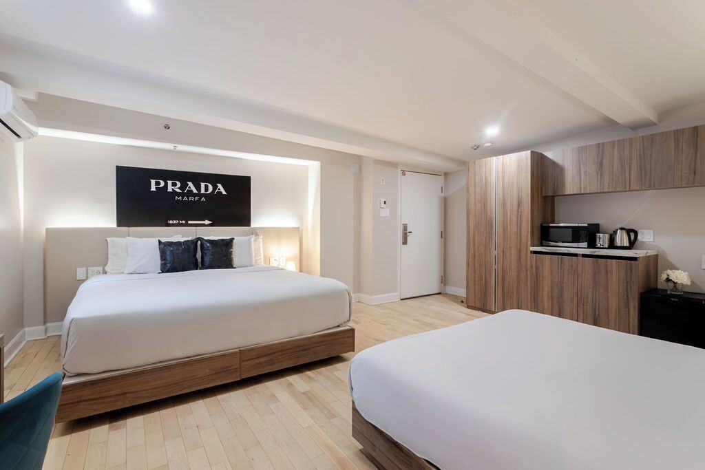 Een moderne hotelkamer met een groot bed, een minibar en een kledingkast.