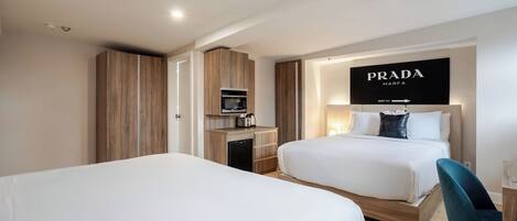 Habitación de hotel con dos camas, un minibar, un televisor y un letrero de Prada en la pared.