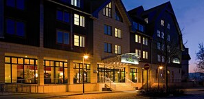 A hotel with a modern facade, multiple windows, and a well-lit entrance.