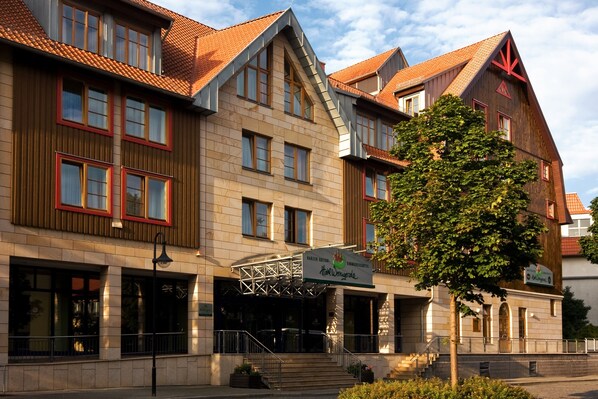 A hotel with a traditional European architectural style, featuring a prominent entrance with a staircase and a signboard.