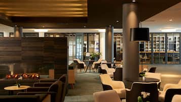 Un espace de détente moderne avec des canapés, des tables et une cheminée.