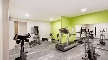 A gym with treadmills, weight machines, and free weights.