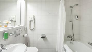 Un baño moderno con lavamanos, inodoro y bañera blancos.