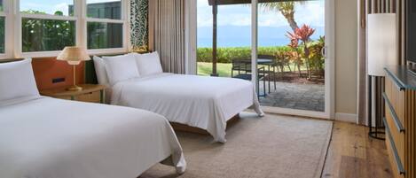 Habitación de hotel con dos camas, un ventanal con vistas al exterior, una puerta corrediza de vidrio que da a un patio y un televisor a la derecha.