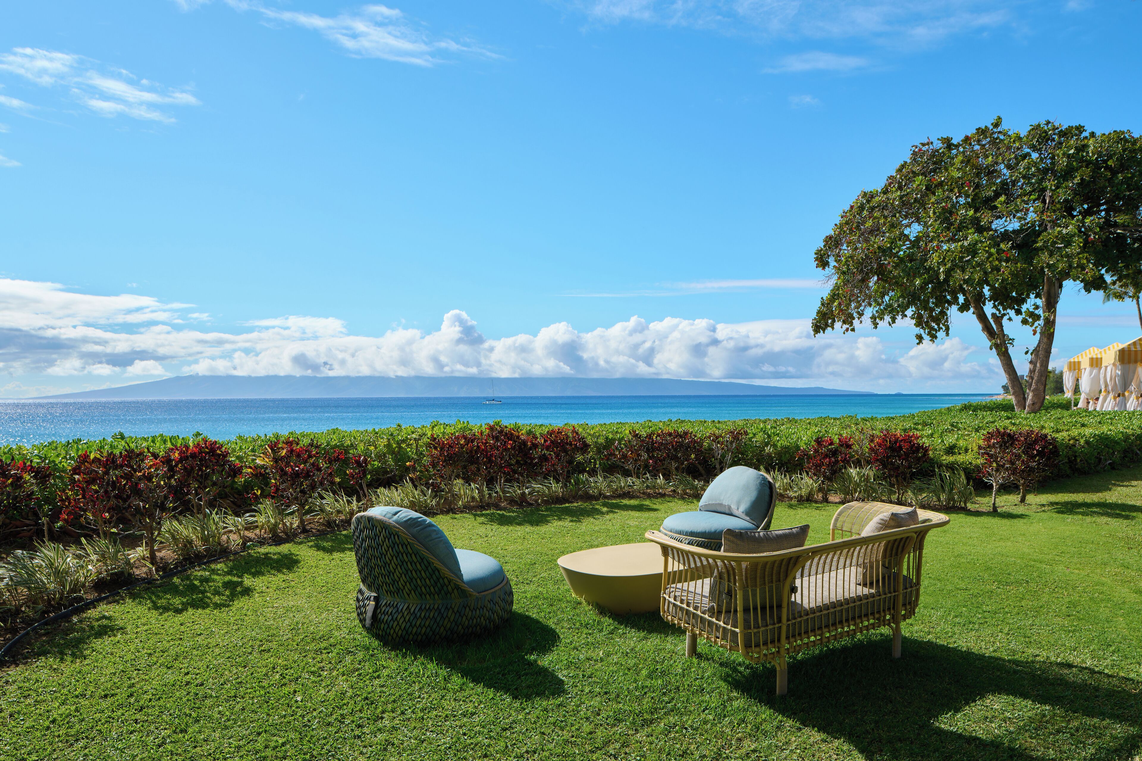 På stranden, hvit sand, strandtelt (mot et tillegg) og solsenger