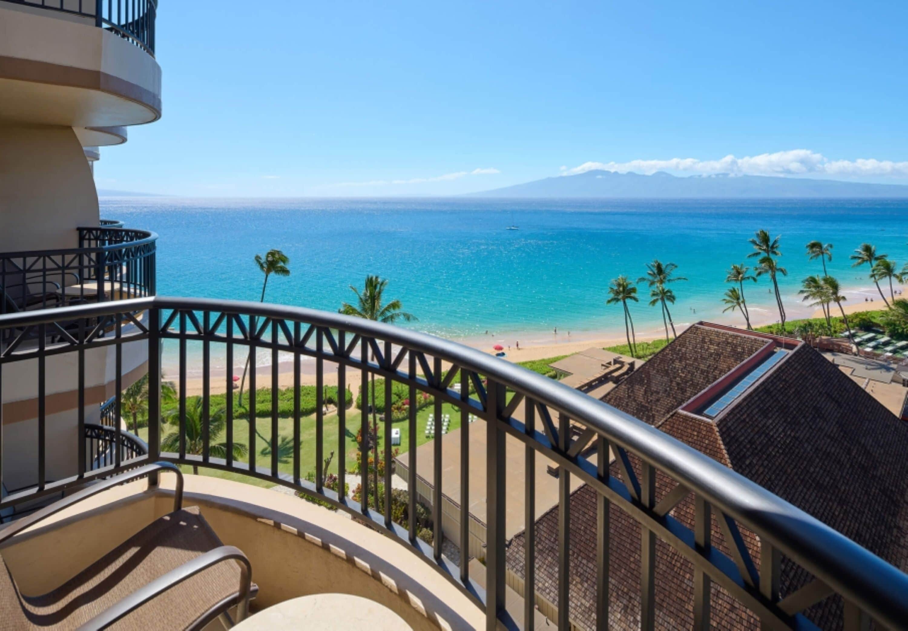 Un balcon avec vue sur une plage et l’océan.