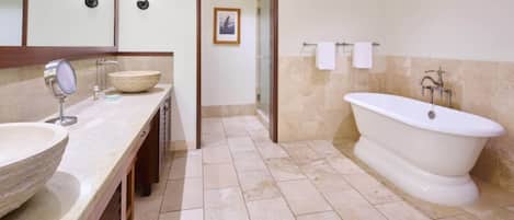 Un baño con una bañera grande, un lavabo doble y un lavamanos.