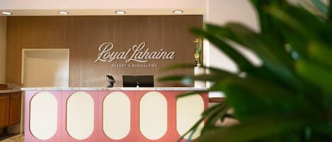 En receptionsdisk med en skylt som visar texten: ”Royal Lahaina Resort & Bungalows”.