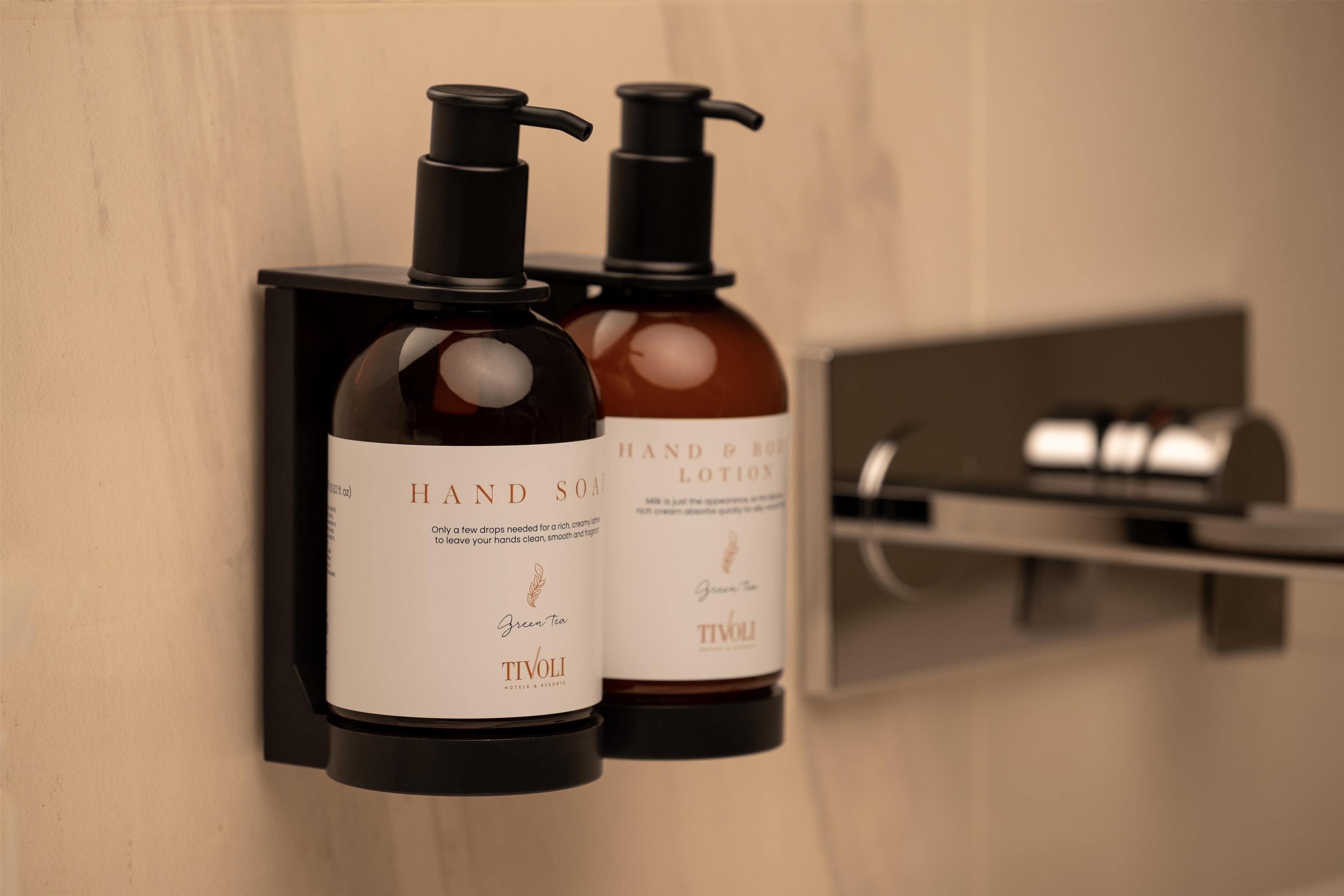 Two hand soap bottles mounted on a wall.