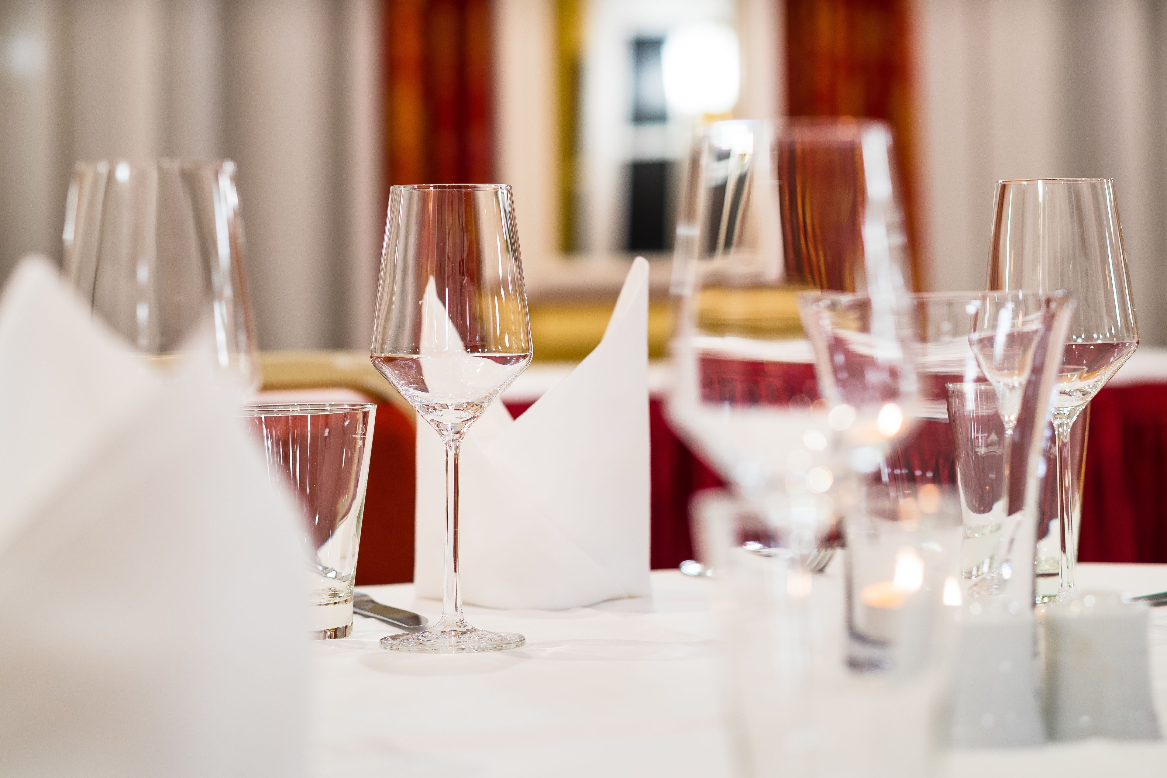 A dining table set with multiple wine glasses and a white napkin.