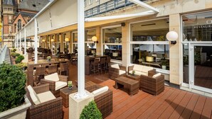 An outdoor seating area with wicker furniture and potted plants. - Hotel Chemnitzer Hof (Chemnitz)