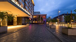 A hotel entrance with a modern design, featuring a prominent sign and a well-lit pathway leading to the entrance.