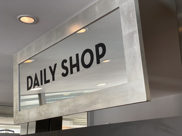 A sign with the text "DAILY SHOP" in a modern, industrial-style building.