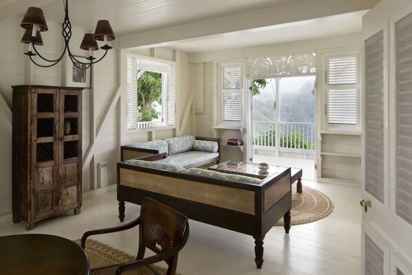 Un dormitorio amplio con una cama grande, un aparador de madera y vistas a zonas verdes.