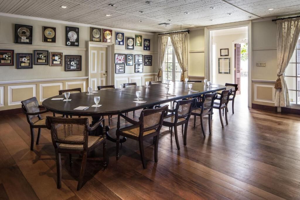 Une salle de conférence avec une longue table, des chaises et des trophées encadrés accrochés aux murs.
