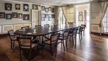 Une salle de conférence avec une longue table, des chaises et des trophées encadrés accrochés aux murs.