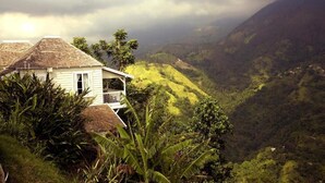 Una casa con balcón que da a un valle exuberante.