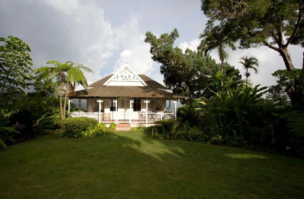 A house with a triangular roof and a porch with white railings.