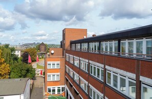Un edificio de varios pisos con fachada de ladrillo, ventanas grandes y techo plano.