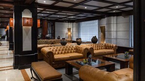 A spacious lobby with leather sofas, a coffee table, and decorative vases. - Hotel Fundador (Santiago)
