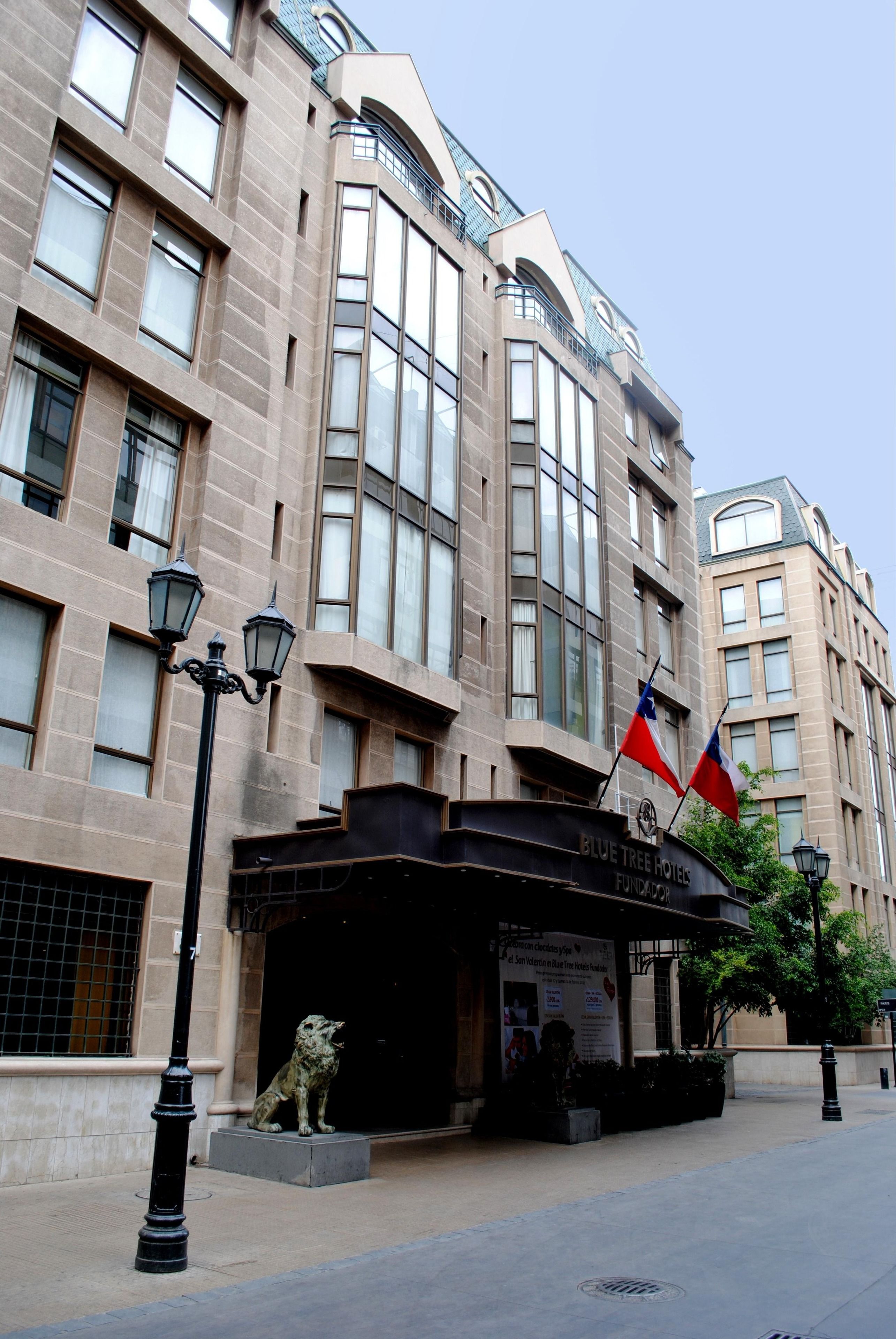 A hotel with a stone facade, large windows, and a sign reading "Blue Tree Hotels Fundador."