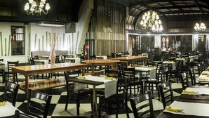 A restaurant with multiple tables and chairs, arranged in a spacious layout. - Hotel Fundador (Santiago)