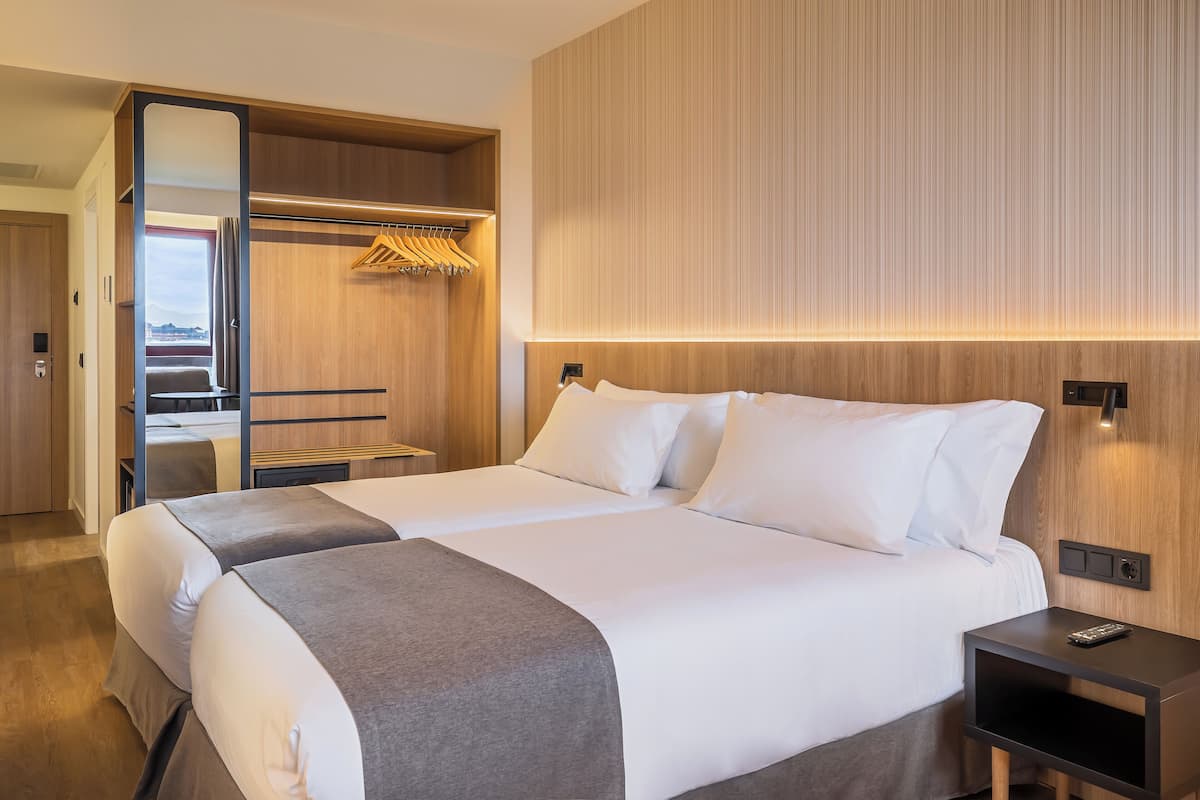Un hotel moderno con una cama grande, un armario y vistas al exterior.