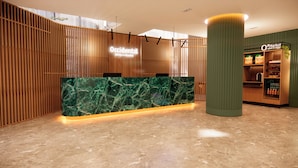 A reception area with a marble counter, wooden paneling, and a sign for O'Market.