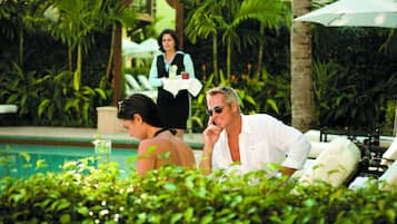 Una piscina al aire libre, sombrillas, sillones reclinables de piscina