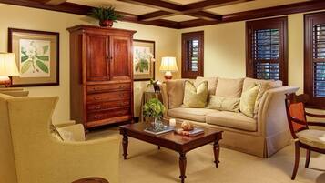 Una sala de estar con un sofá color beige, un aparador de madera y una mesa de centro.