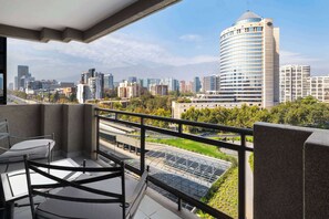 A balcony with a view of a cityscape, including a distinctive curved building and a green park area. - Wyndham Garden Santiago Kennedy (Santiago)
