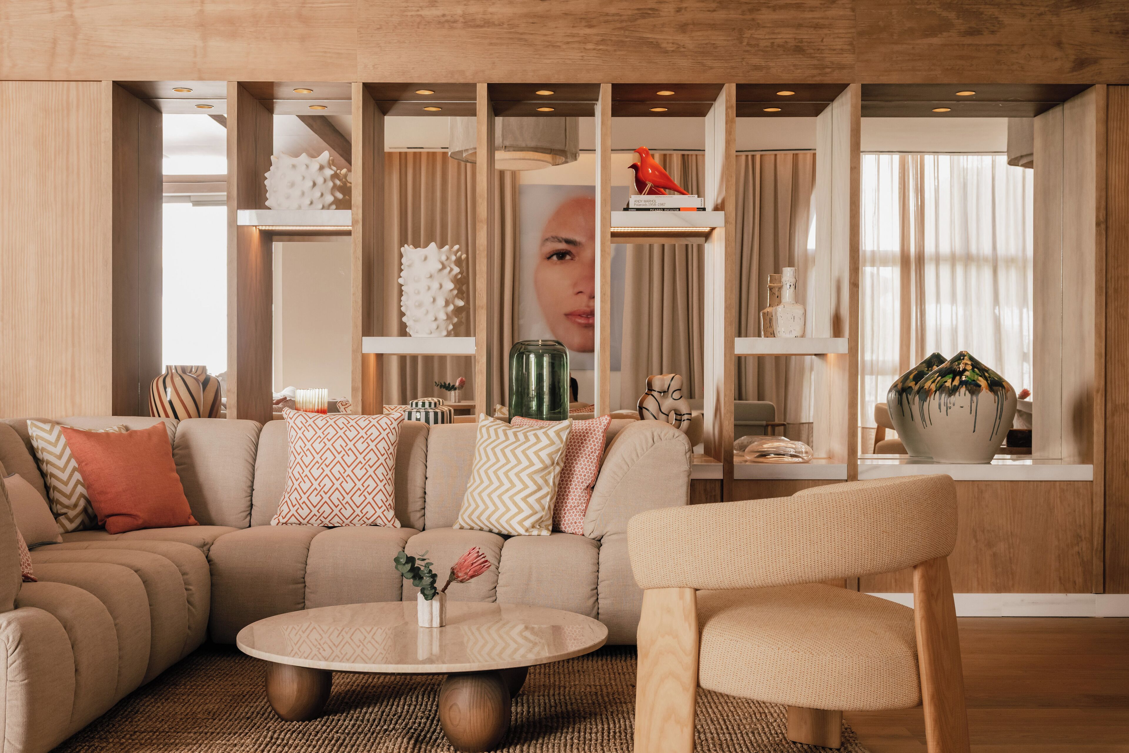 A modern living room with a sectional sofa, a round coffee table, and a side table with decorative items.