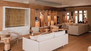 Un salon moderne avec un canapé blanc, une table basse en bois et une grande fenêtre.