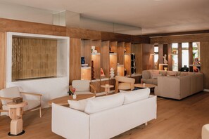 Ein modernes Wohnzimmer mit einem weißen Sofa, einem Holztisch und einem großen Fenster.